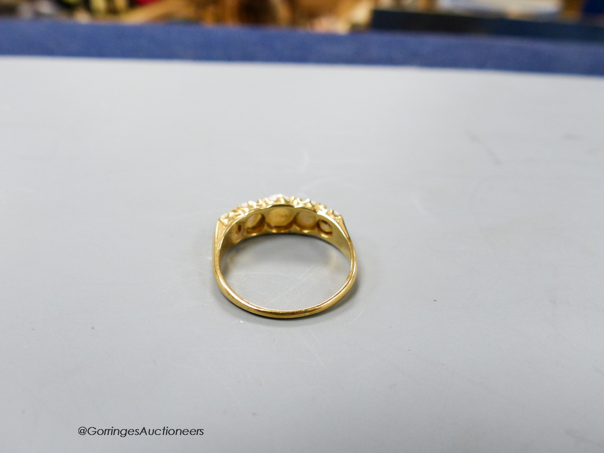A yellow metal and graduated five stone split pearl half hoop ring, size R, gross weight 3.8 grams.